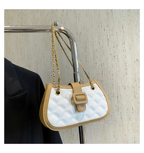 Close-up of quilted white crossbody bag with khaki trim and gold chain strap