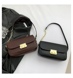 Detail of dark brown and black baguette bags with gold chain straps and metal locks