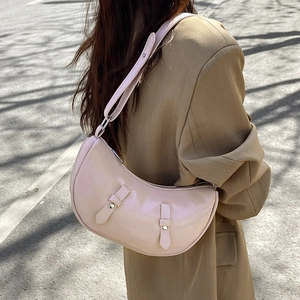 Pale pink hobo crescent bag with leather buckle straps shown on female model