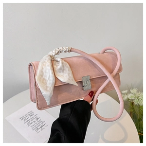 Detail of pink suede shoulder bag with silk scarf accent and diamond-encrusted silver clasp
