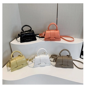 Minimalist mini leather crossbody bags displayed in five colors on a white tiered stand