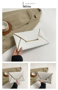 Détails d'une pochette enveloppe blanche en cuir grainé avec finitions dorées chic