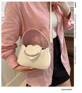 Detail of off-white heart flap handbag with silver bead chain and adjustable shoulder strap