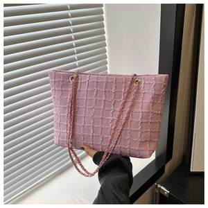 Détail du cabas en tweed rose avec bandoulière en chaîne dorée et tissu tissé
