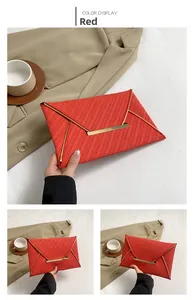 Détail d'une pochette enveloppe rouge avec texture tissée et bordure dorée en V