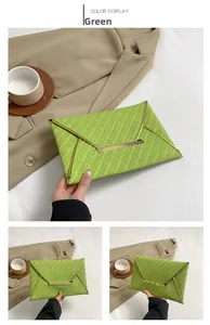 Détail de la pochette enveloppe verte tendance avec texture tissée et bordure dorée chic