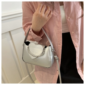 Detail of silver heart-shaped crossbody bag with decorative metal bead chain handle