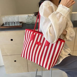 Minimalist red and white striped large canvas tote bag with red leather straps on a model