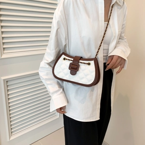 Quilted white and brown leather crossbody bag with elegant gold chain strap worn by model