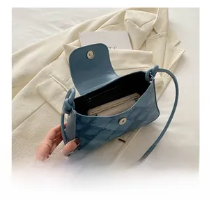 Detail view of the blue quilted underarm bag showing interior capacity and magnetic closure