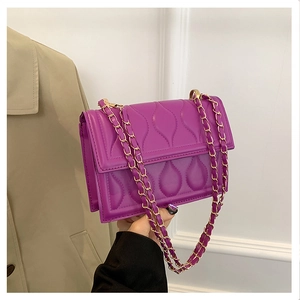 Détail du sac à main violet en similicuir matelassé avec élégante chaîne dorée