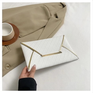 Vue détaillée de la pochette enveloppe blanche avec bordure dorée et texture tissée