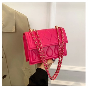 Détail du sac matelassé fuchsia avec bandoulière chaîne dorée et similicuir gaufré