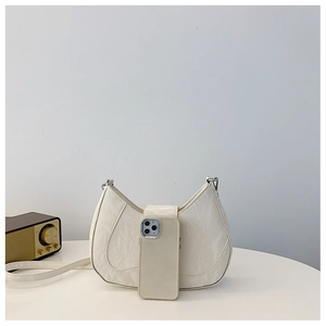 Detail of creamy off-white leather shoulder bag with textured pleats and phone for scale