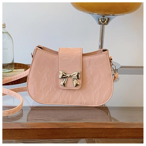 Dettaglio della borsa in pelle verniciata rosa con fibbia in metallo a fiocco d'oro