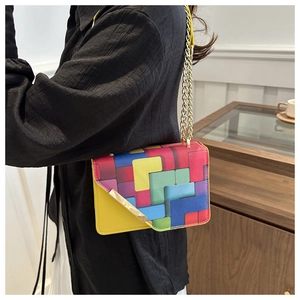 Detail of colorful geometric block pattern crossbody bag with gold chain strap