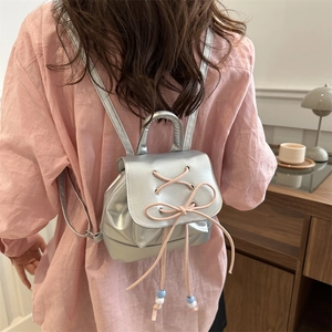 Silver metallic mini backpack with pink bow detail and ballet-style crossover ribbons