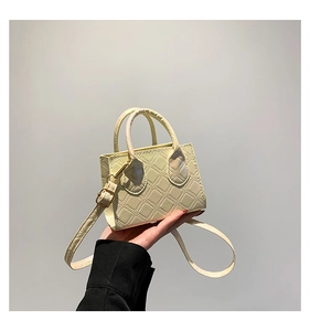 Détail du sac à main matelassé jaune clair avec garniture dorée et bandoulière amovible