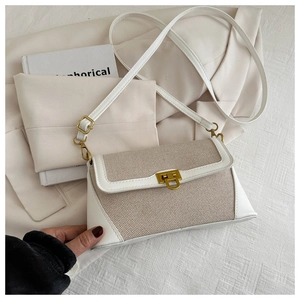 Detail of a French vintage beige patchwork shoulder bag with gold buckle clasp