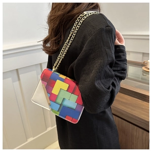 Model wearing a small crossbody bag with colorful geometric blocks and golden chain