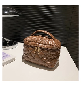 Dettaglio della borsa da trucco in nylon trapuntato marrone con doppia zip dorata
