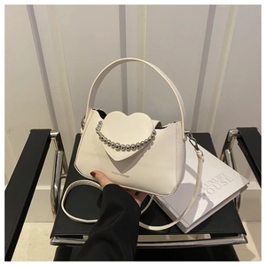 Detail of white heart-shaped leather bag with silver bead chain and brand logo