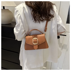 Brown litchi texture leather crossbody bag with a gold square buckle and adjustable strap