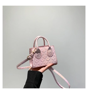 Gros plan du mini sac à main rose matelassé avec quincaillerie dorée et anses rondes