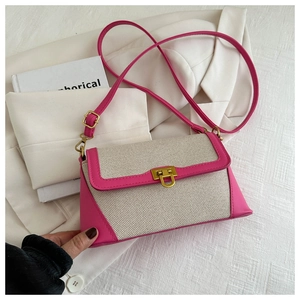 Detailed close-up of a French baguette bag featuring a gold U-shaped lock and beige canvas