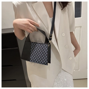 Détail du mini sac en cuir à motif vintage avec boucles dorées et bandoulière fine