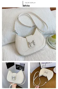 Close-up of cream crescent bag with vintage texture and silver bow buckle detail