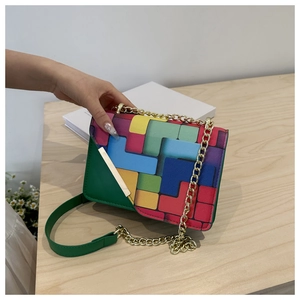 Macro shot of geometric color-block patchwork leather and gold metal buckle detail