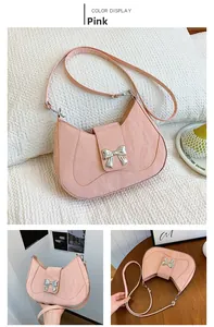 Close-up of pink crescent underarm bag with silver bow hardware and pleated texture