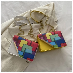 Detail of color-block flap bags with geometric patterns and golden metal chain straps