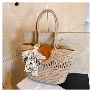 Detail of woven beach tote with leather flap, pearl clasp, and decorative lace bow