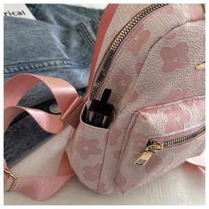 Detail eines rosa Jacquard-Mini-Rucksacks mit Seitentasche für Lippenstifte und Textur