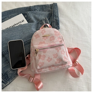 Detailansicht eines rosa Jacquard-Rucksacks mit Blumenmuster und goldener Metallplatte