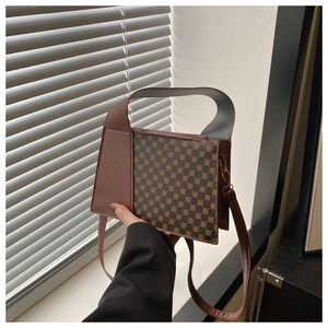 Détail du sac à main vintage montrant l'imprimé géométrique et la texture de l'anse en cuir