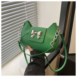 Dettaglio borsa a mano verde brillante con fiocco in metallo argento e tracolla a catena