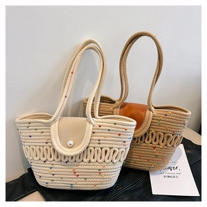 Detail of hand-woven cotton rope tote bags in cream and camel with pearl buckles