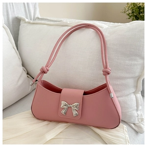 Detail of pink baguette bag with silver metal bow and knotted shoulder strap