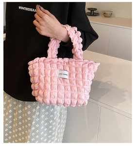 Detail of pink bubble texture handbag with LOVE FASHION label and stylish puffed material