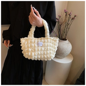 Close-up of cream textured bubble tote bag with Love Fashion label and elegant pleated finish
