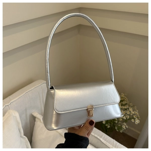 Detailed view of a silver baguette bag with a sleek metallic finish and gold buckle