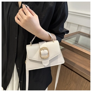 Close-up of white lychee leather Kelly bag with oversized gold woven metal buckle