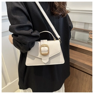 Detail of creamy white litchi pattern leather bag with woven gold buckle