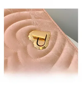 Close-up of pink heart-quilted texture and elegant heart-shaped gold metal buckle
