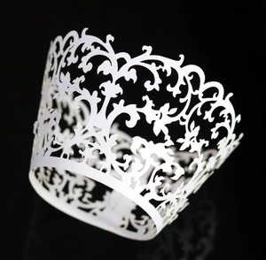 Elegant white laser-cut cupcake wrappers with intricate floral lace pattern for weddings