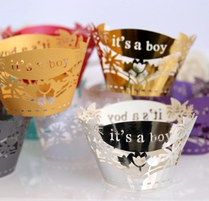 Laser cut cupcake wrappers with it's a boy text and floral patterns in pearl colors