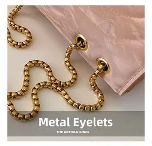 Detail of glossy gold chain threading through metal eyelets on pink quilted bag